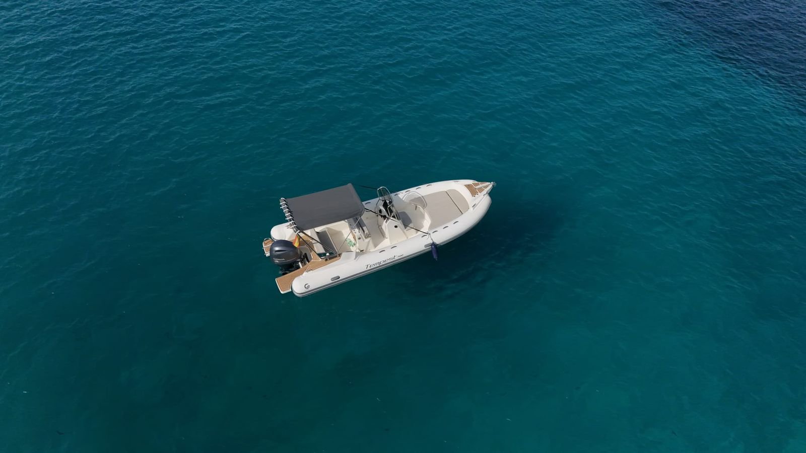Drone shot of boat cruising over crystal-clear Mediterranean water near Mallorca's west coast